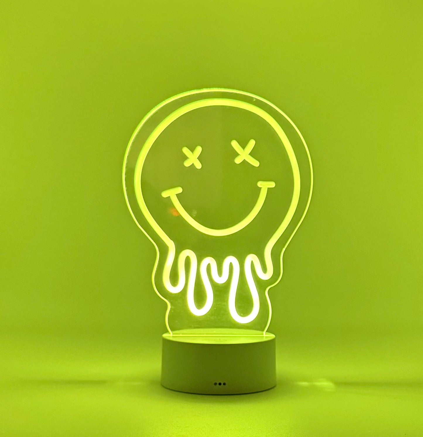Neon light shaped like a jellyfish with a smiley face on a green background