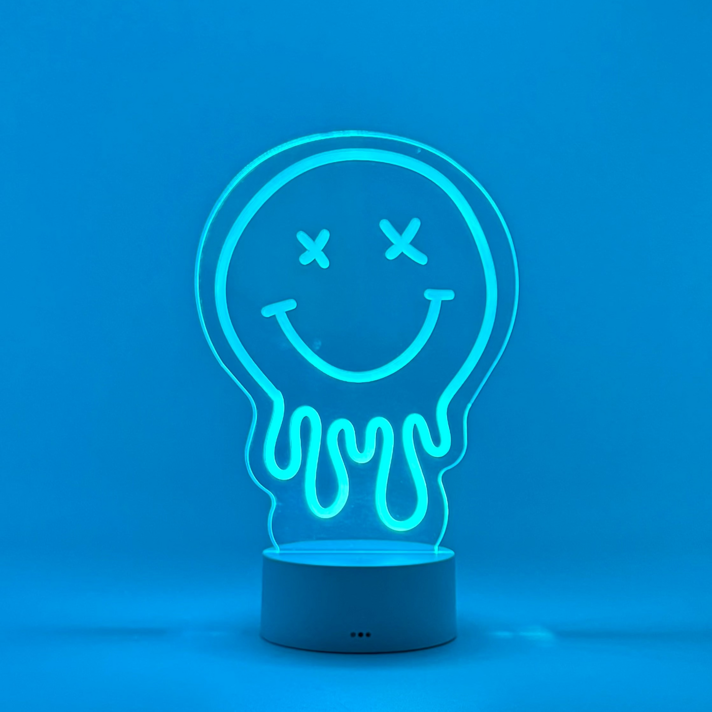Neon light shaped like a smiley face inside a light bulb on a blue background
