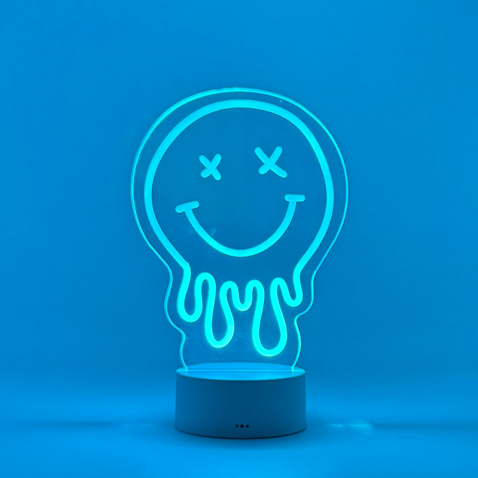Neon light shaped like a smiley face inside a light bulb on a blue background