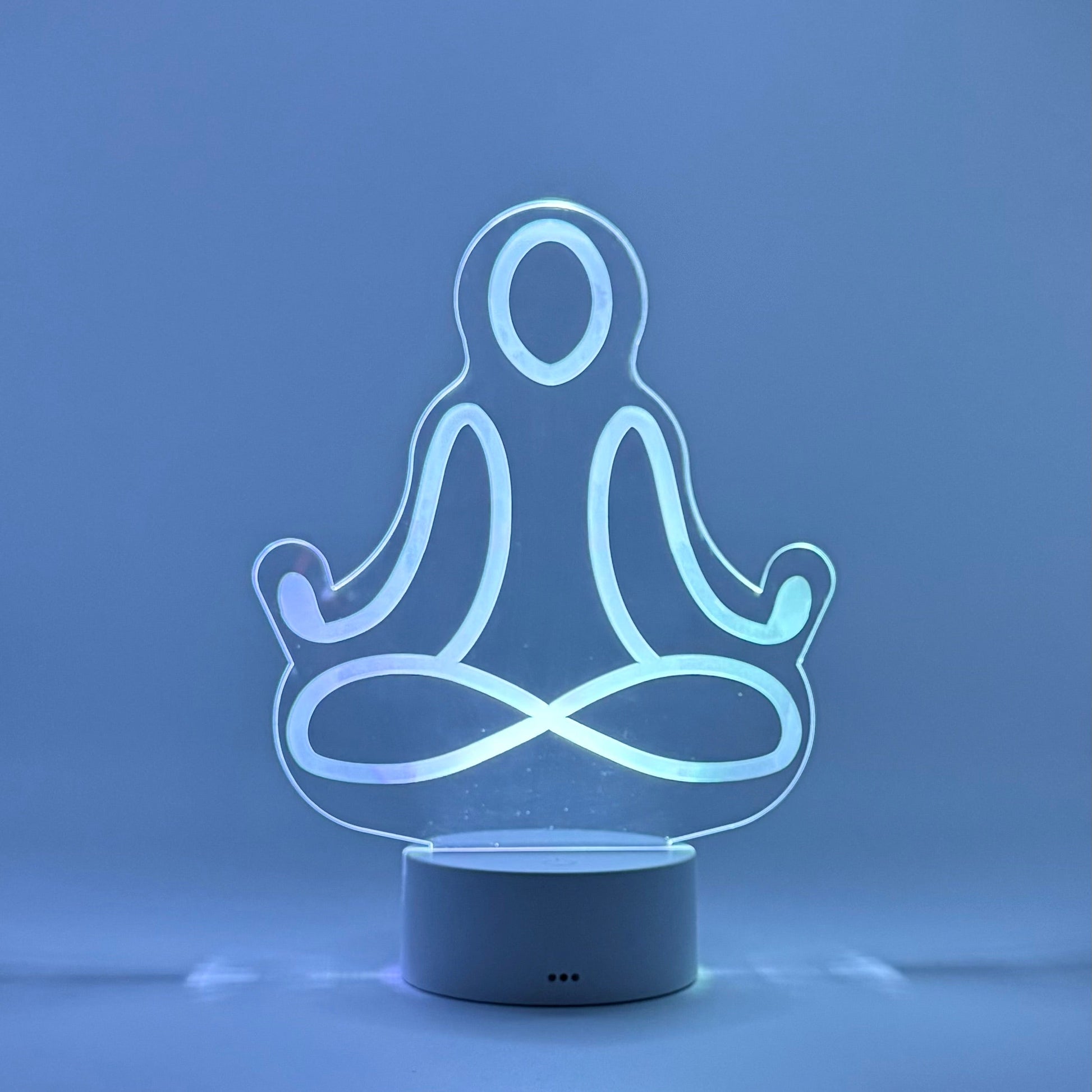 LED lamp shaped like a person in a meditative pose on a blue background