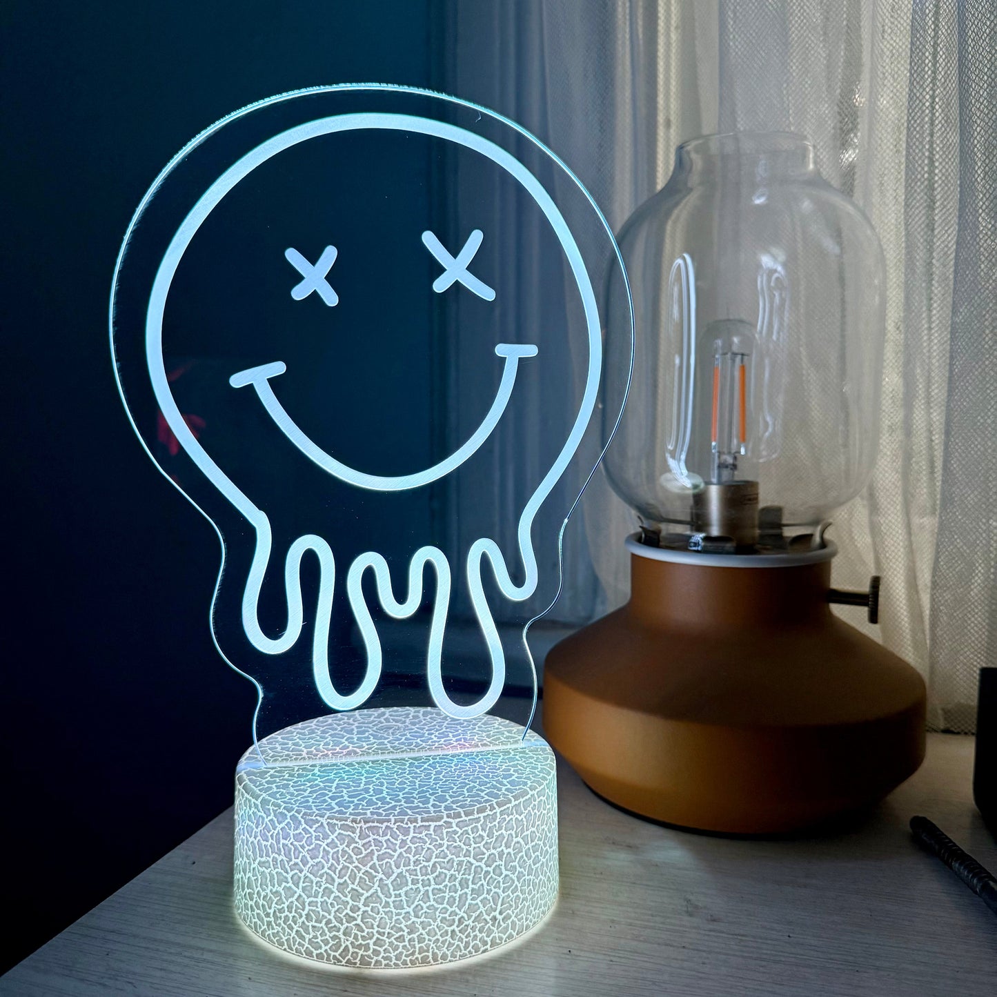 Neon light shaped like a smiley face with a bulb design on a table.