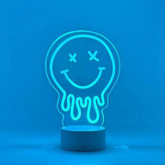 Neon light shaped like a smiley face inside a light bulb on a blue background