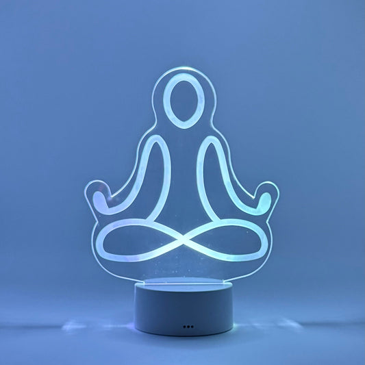 LED lamp shaped like a person in a meditative pose on a blue background