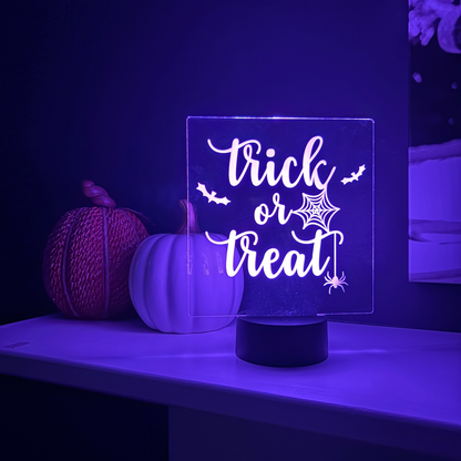 Halloween-themed night light with 'Trick or Treat' text on a dark background