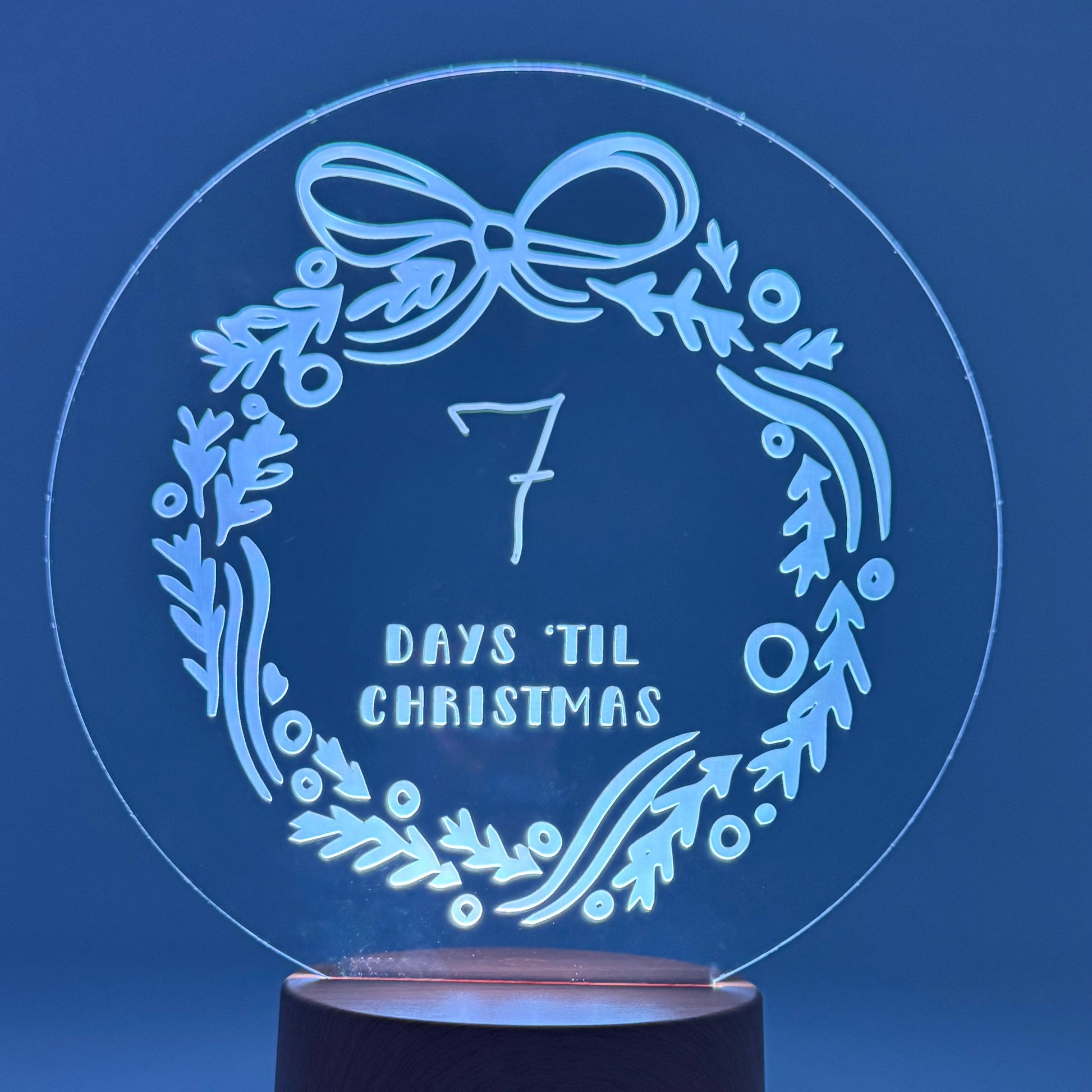 Decorative night light with '7 days 'til Christmas' design on a blue background